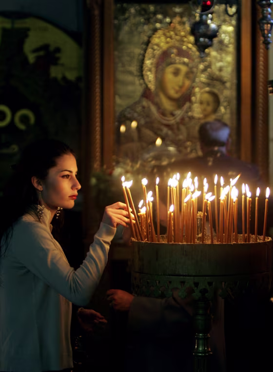 Christian woman lights candles during th