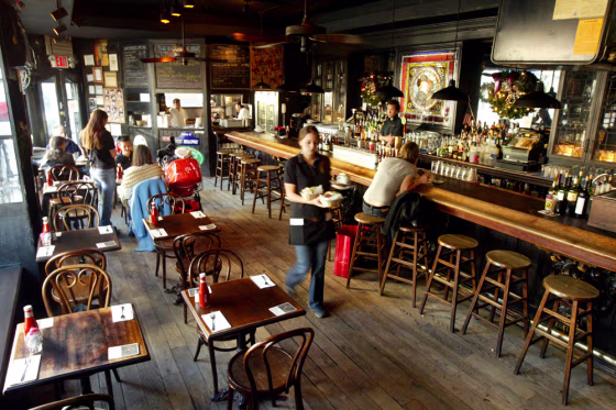 Tables are almost all empty and only one customer is seated at the bar during lunch hour at Kenn's Broome St. Bar in New York on Wednesday.