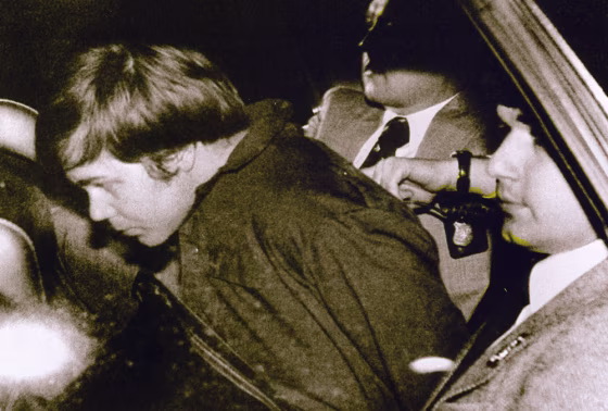 John Hinckley Jr. (L) escorted by police in Washington, DC, on March 30, 1981 after he shot and seriously wounded President Ronald Reagan.