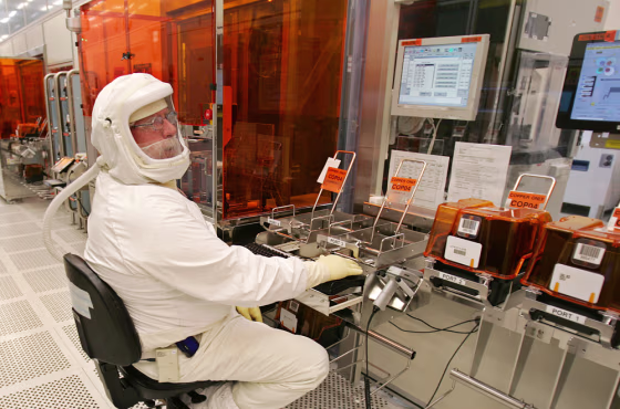 An Intel Corp. manufacturing technician produces computer chips in a clean room at Intel headquarters in Santa Clara, Calif., earleir this year. Instead of remaining focused on PCs, Intel is pushing to play a key technological role in a half-dozen fields, including consumer electronics, wireless communications, and health care.