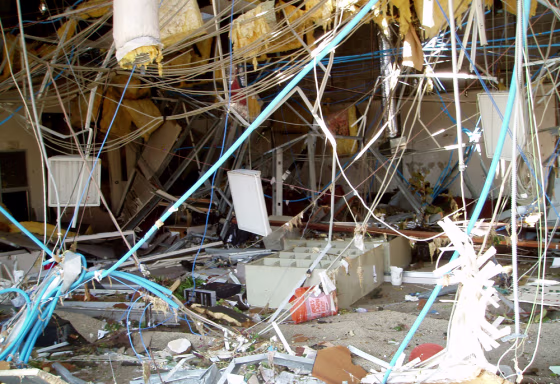 The Gulfport, Miss., office of Sawyer Real Estate lies in ruins after Katrina. One black PC can be seen on the ground, to the left of the toppled bookshelf in the center of the photo. 