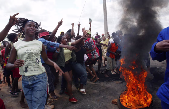 South African youth demonstrate by a burning tire near a polling station in the township of Khutsong, west of Johannesburg, on Wednesday. South Africans went to the polls for local elections dominated by widespread dissatisfaction with lack of services and corruption. 