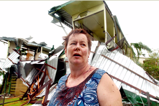 Covered in blood, Kate Charleston stands outside her home in Innisfail, Australia, from which she narrowly escaped on Monday. State and federal governments declared a state of emergency within hours.