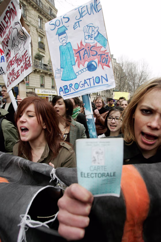 Students, one brandishing her voting card, right, march through Paris during a demonstration Thursday.
