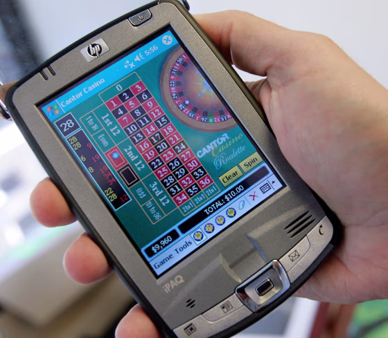 Joseph Asher, managing director of Cantor G&W, holds an HP PDA with a roulette wheel program, one of many gambling programs available, June, 2005 