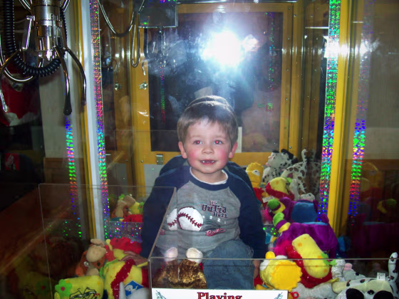 Devin Haskin, 3, plays inside the Toy Chest claw machine at Godfather's Pizza on Sunday in Austin, Minn., after crawling through the toy discharge chute.