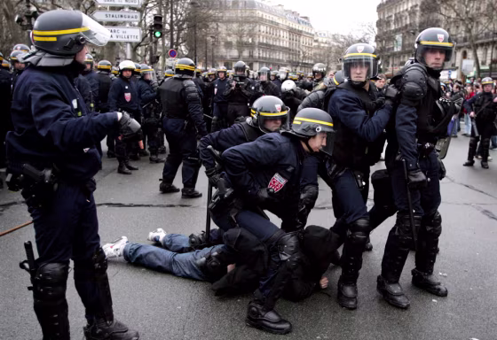 French riot police apprehend a youth during clashes at end of protest in Paris