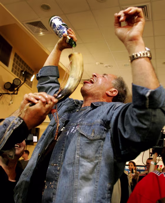 An Israeli Labor party supporter drinks champagne in Tel Aviv