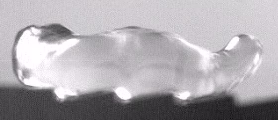 A water droplet wriggles up a hot piece of brass with sawtooth ridges, like an inchworm. 
