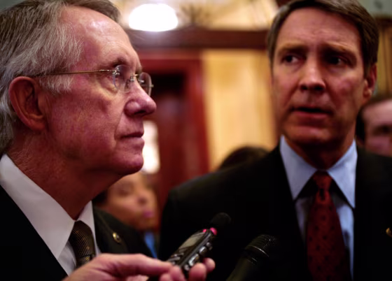 Senate Minority Leader Harry Reid (D-Nev.), left, and Senate Majority Leader Bill Frist (R-Tenn.), right, answer questions from reporters about the immigration legislation.