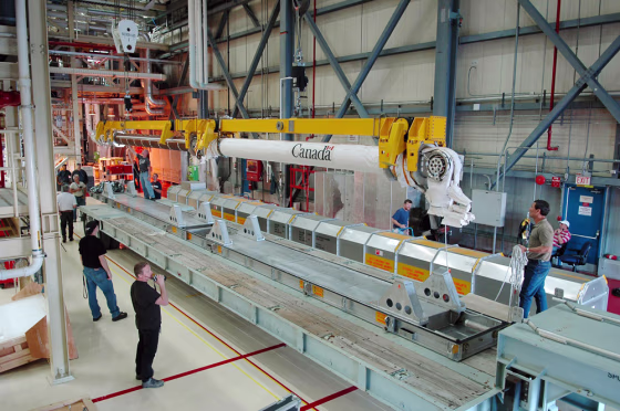 Discovery's robotic arm is lowered onto a flatbed in a work area inside NASA's Orbiter Processing Facility in mid-March, after&nbsp;the arm&nbsp;was accidentally bumped by a&nbsp;platform in the payload bay.