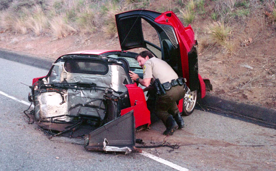 A Los Angeles County sheriff's deputy inspects the remains of a rare Enzo Ferrari that crashed on the Pacific Coast Highway on Feb. 21 in Malibu, Calif.