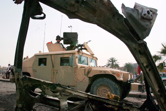 A U.S. Army Humvee passes the wreckage of a car bomb in Baghdad on April 3.