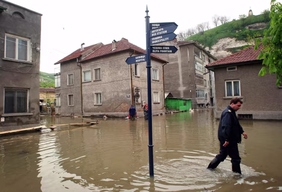 Bulgarian civil defense officer walks on flooded street in town of Nikopol