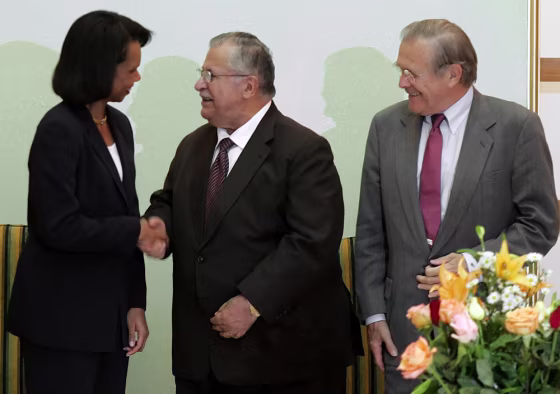 US Defence Secretary Rumsfeld looks on as US Secretary of State Rice shakes hands with Iraqi President Talabani in Baghdad