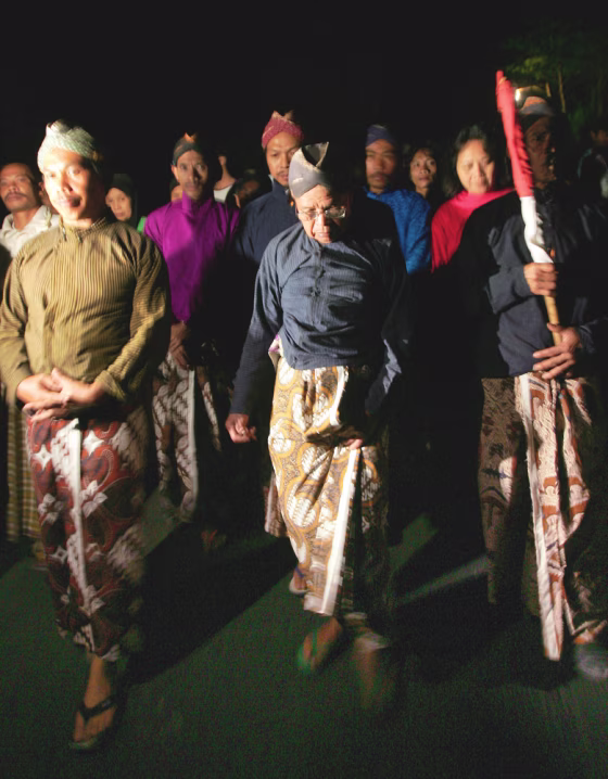 Wearing traditional dress, Maridjan, center, the spiritual guardian of Mount Merapi, and other villagers&nbsp;circle their village late Thursday night as a part of a&nbsp;prayer for protection from the rumbling volcano.&nbsp;The men later asked journalists to leave and it was reported that they removed their clothes as part of&nbsp;the ritual.&nbsp; 