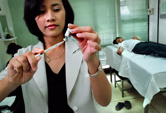 A nurse prepares a syringe with an experimental AIDS vaccine at a clinic in Bangkok. The U.S.-funded trial will involve 16,000 test subjects.