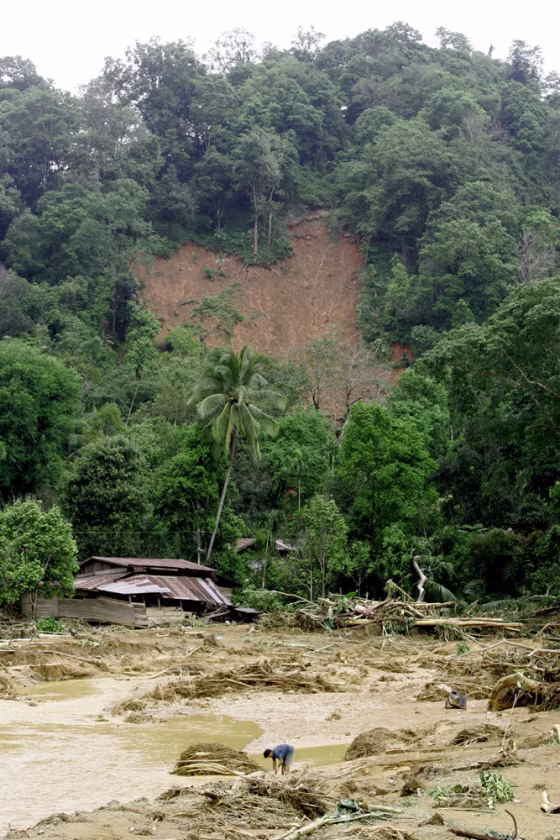 A Thai villager washes his hands in the stream created by a flash flood near his partly destroyed house in Uttaradit province, northern Thailand, on&nbsp;Wednesday.