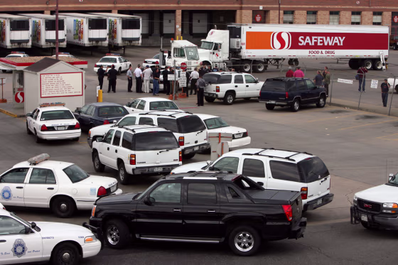Police vehicles block the entrance to a Safeway distribution center in Denver after Sunday's shooting.