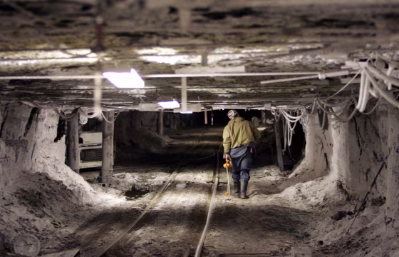 A worker in an Alabama coal mine walks beside a rail car track. American mining operations of all types are experiencing shortages of equipment and workers.