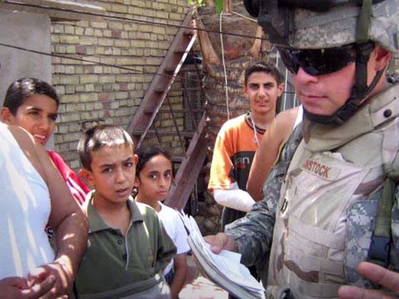 Capt. Mike Comstock, right, interviews residents in the Bayaa neighborhood of Baghdad.