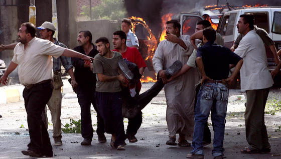 Iraqis wounded in a massive car bomb near a bank in Baghdad are carried away&nbsp;Tuesday morning.