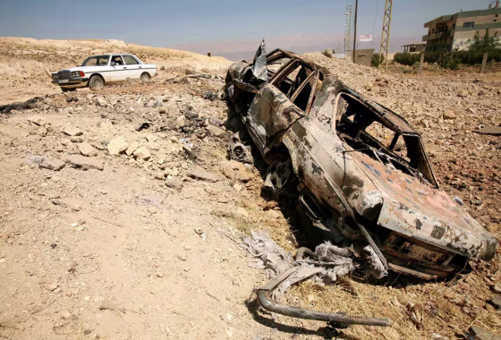 A car lies on a road after an Israeli attack in the city of Baalbeck
