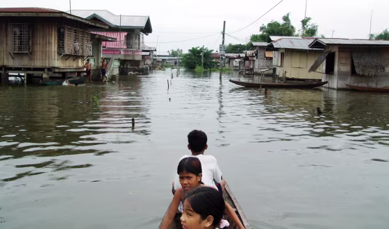 Residents use a boat in flood waters in a town near Candaba, Pampanga province, north of Manila