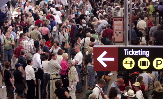 Travelers fill the concourse as they wait to go through a security checkpoint at the Sea-Tac International Airport in Seattle on Aug. 10.