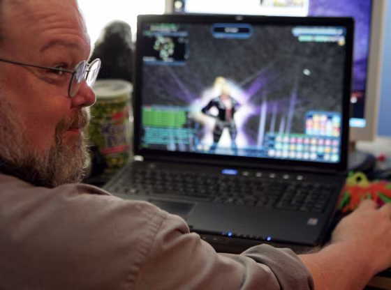 Freeman Williams sits in front of his home computer in Houston with his virtual alter-ego, video game super hero Robotrixie, on the screen.