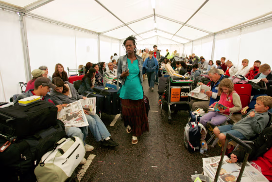Passengers needing to check in for flights wait in a tent errected outside of Lodon's Heathrow Airport's terminal four on Monday.