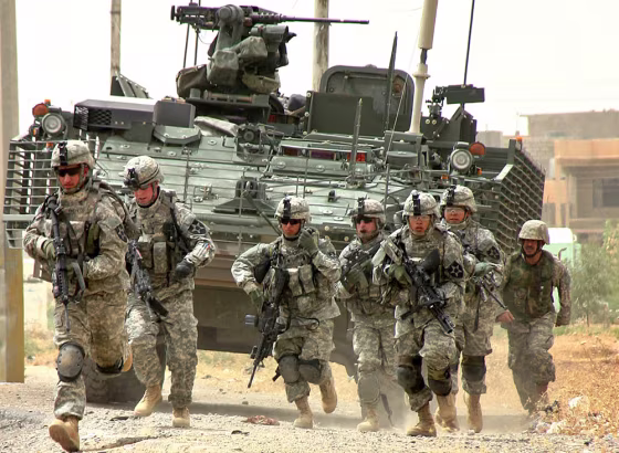 U.S. troops take their positions as shots are fired after a suicide car bomb attack in Mosul