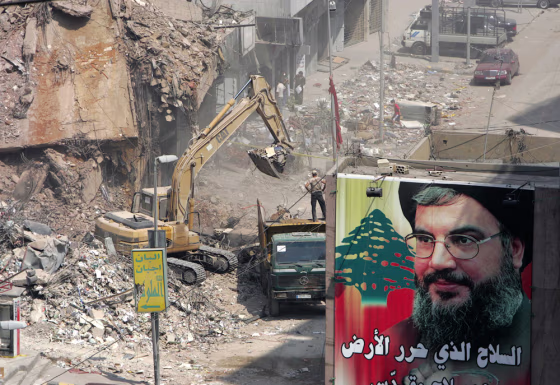 Poster of Hizbollah leader Sayyed Hassan Nasrallah is hung near rubble of damaged building in Beirut's southern suburbs