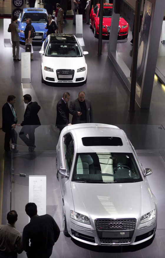 Visitors look at cars during the opening