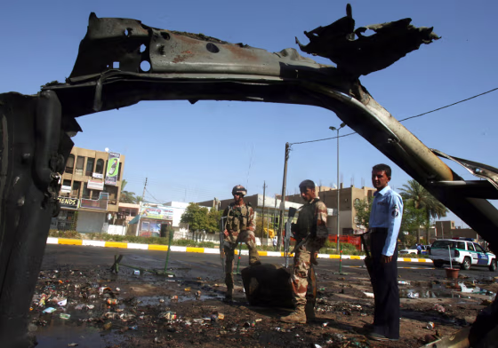 Iraqi soldiers view the wreckage of a car bomb that detonated near a&nbsp;police patrol in Baghdad on&nbsp;Thursday.