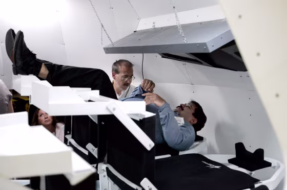 AP reporter Seth Borenstein, right, gets situated&nbsp;in the&nbsp;mockup of the Orion spacecraft with the help of Lockheed Martin engineer Marc Sommers.