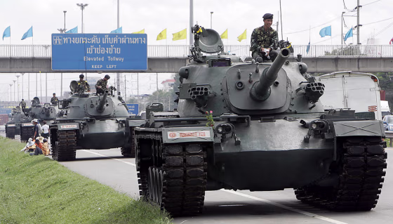 A column of military tanks guard a highw