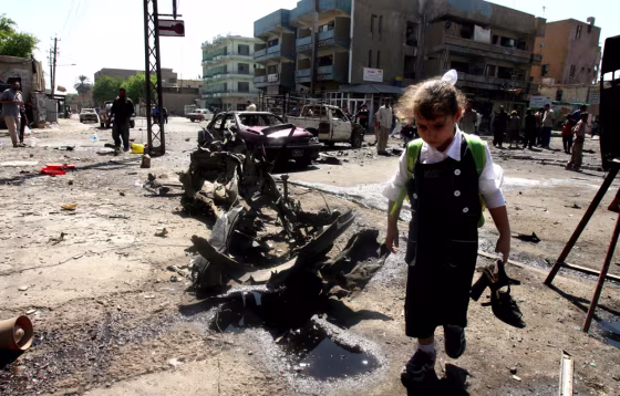 An Iraqi girl takes home her older sister's shoes from a site near Abu Tibeekh restaurant in Sadoun Street in central Baghdad&nbsp;where a car bomb explosion killed five people and wounded 34 Thursday. It was unclear if her sister was injured in the attack.