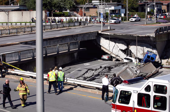 Rescue workers survey the site of an overpass in Laval, Quebec on&nbsp;Saturday.