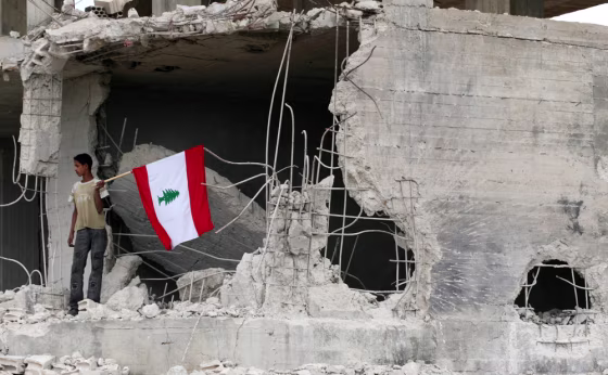 Lebanese villager waves a flag in Marwahine village after Israeli forces withdrew from village in south Lebanon