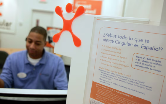 A Cingular employee works by a bilingual sign at a Cingular Wireless store in Silver Spring, Md., Monday, Oct. 9, 2006. Latinos — the fastest-growing minority group in the U.S. — are expected to have $1 trillion in buying power by 2010.