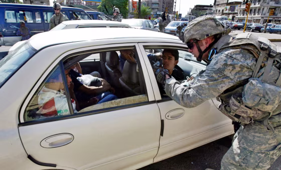 A US soldier searches a car at a snap ch