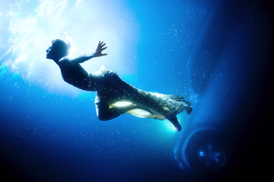 Actress and model Eva Mendez, dressed in a couture gown, swims in front of a Mercedes GL450 in an image called ‘The Sinking Fear.’
