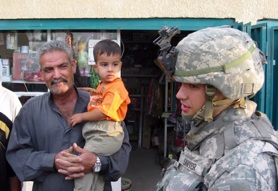 Capt. Adam Sawyer, 28, of Reading, Pa., speaks with Samir Hassan, 53, a storeowner in the small village of Mustafar, Iraq, about how to improve security there. Sawyer's regiment is working to improve services in towns south of Baghdad as part of an effort to win over the local population and to get them to trust Iraqi security forces.