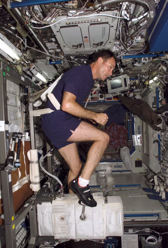 Space station commander Michael Lopez-Alegria watches movies during his daily exercise routine.