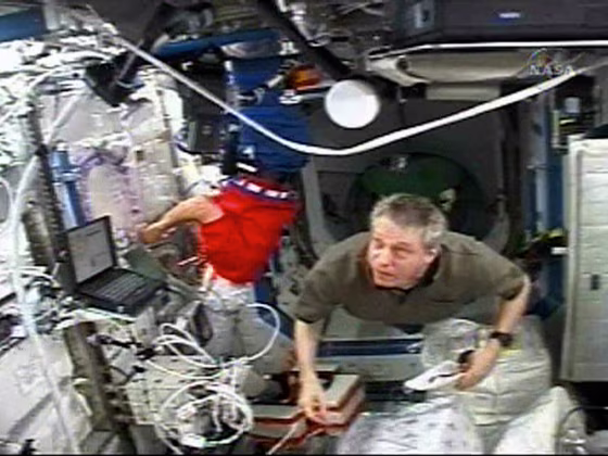 European Space Agency astronauts Christer Fuslesang and Thomas Reiter work in the Destiny laboratory module