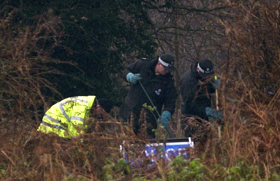 British police officers look for clues in a wooded area near where the bodies of murdered prostitutes Paula Clennell and Annette Nicholls were found on Dec. 12 near Levington, England.