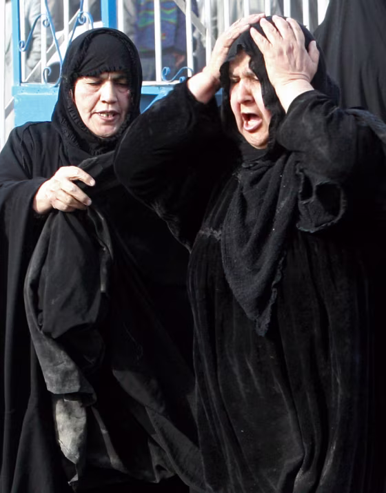 Woman cries as she waits to claim body of her son outside Kindi hospital in Baghdad