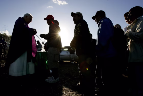 Worshipers receive communion from Monsignor Frank Fawcett during a service near McGonigle Canyon in Del Mar, Calif., on&nbsp;Dec. 17. 