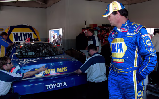 NASCAR driver Michael Waltrip, right, watches as his crew works on his Toyota during practice earlier this week. Waltrip’s cheating scandal has dented the automaker’s Daytona debut.